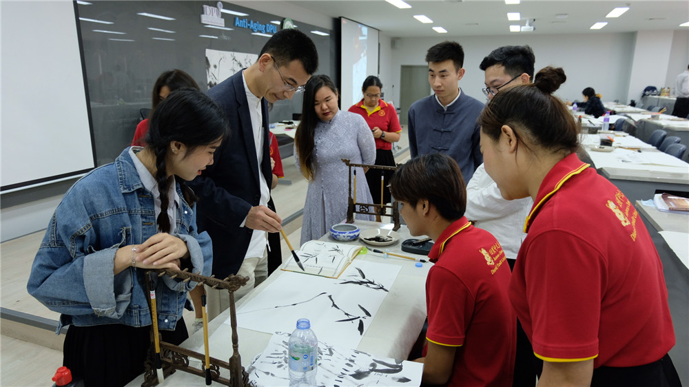 图6.姜教授在中国国画讲座中指导学生作画